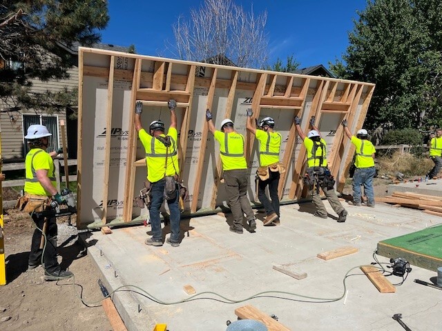 Team raising walls during a group build day at Bend-Redmond Habitat for Humanity